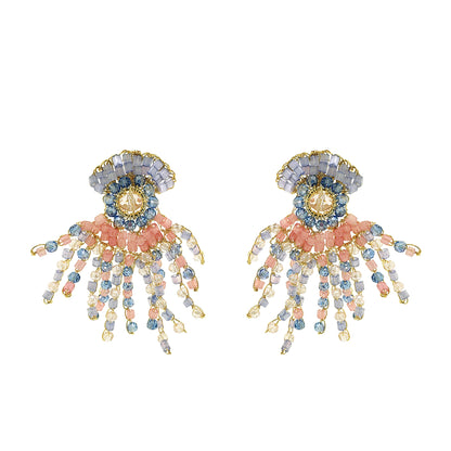 Pair of decorative earrings with floral and organic design and beads on a white background