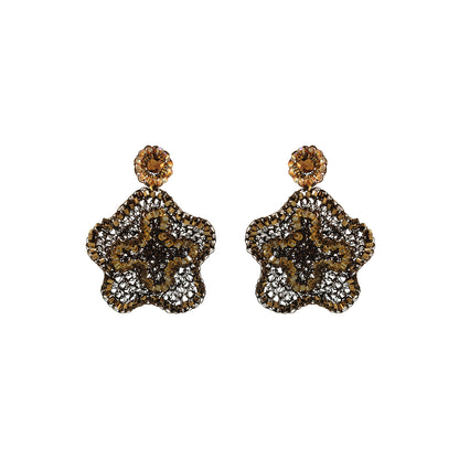 A pair of ornate dangle earrings with a gold-tone floral starburst design, heavily embellished with clear pavé stones and featuring a round amber-brown top stone, shown on a plain white background.