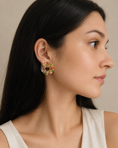 Woman wearing colorful floral earrings against a neutral background-Handmade in Brazil, these petite hand crocheted post earrings feature shiny 18 karat plated wire, lightweight comfort, and hypoallergenic nickel free materials. 4297-001-A069