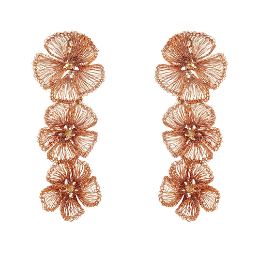Pair of rose gold floral earrings on a white background