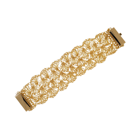 A gold-colored hand-crocheted wire bracelet with a shell pattern and a magnetic clasp. Hand-crocheted 18k gold filled shell cuff bracelet handmade in Brazil, lightweight hypoallergenic nickel-free artisan jewelry with magnetic clasp.