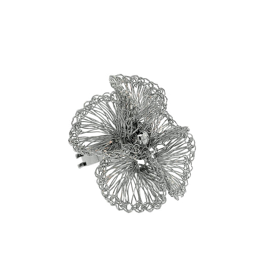 A silver crochet ring with a floral design, displayed against a white background.