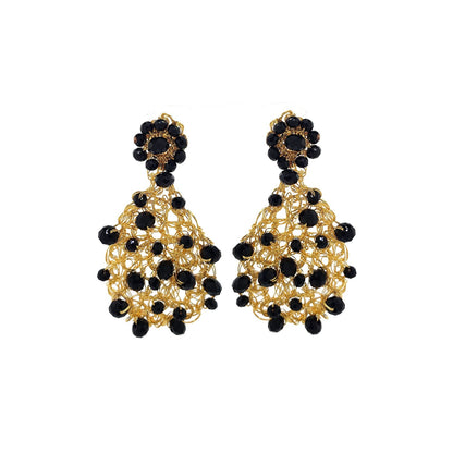A pair of teardrop-shaped hand-crocheted mesh earrings with black crystals and gold-filled copper wire. Handmade in Brazil, these teardrop mesh earrings feature 18 karat gold filled wire, multicolor crystals, lightweight comfort, and hypoallergenic materials.