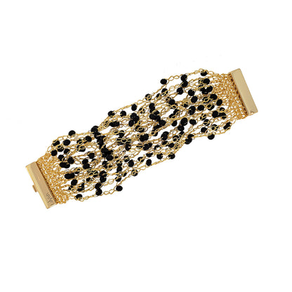 A hand-crocheted gold and black multi-string cuff bracelet with a shiny finish and sparkling crystals, secured by a magnetic clasp. Hand-crocheted gold cuff bracelet handmade in Brazil with 18 karat gold filled wire, black bead accents, sparkling crystals, and magnetic clasp.