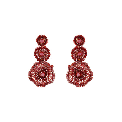 Red hand-crocheted triple drop statement earrings with layered circular design, sparkling bead accents, and enameled copper wire, handmade in Brazil.