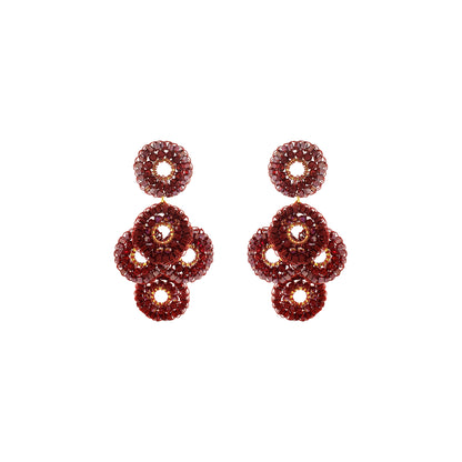 A pair of drop earrings made of multiple stacked circular crystal clusters in a deep burgundy-red hue, set against a plain white background. Shop Burgundy Mix Coco Earrings, handcrafted in Brazil with 18K gold filled and enameled wire. Lightweight crystal statement earrings in rich burgundy tones.