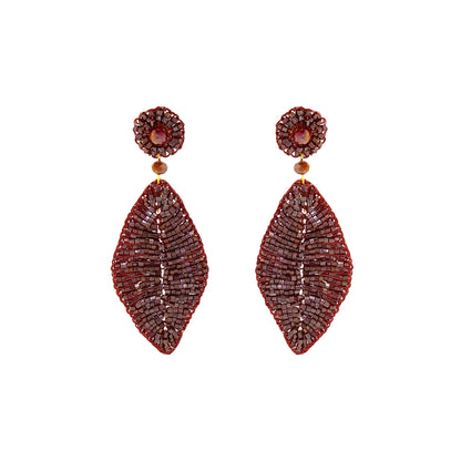 A pair of beaded dangle earrings featuring a circular stud with a central amber bead and a large teardrop-shaped drop made of intricate red and brown seed beads, set against a plain white background. Burgundy Mix handmade crochet leaf earrings with shimmering beads, crystals and an elongated open leaf silhouette, handcrafted in Brazil.