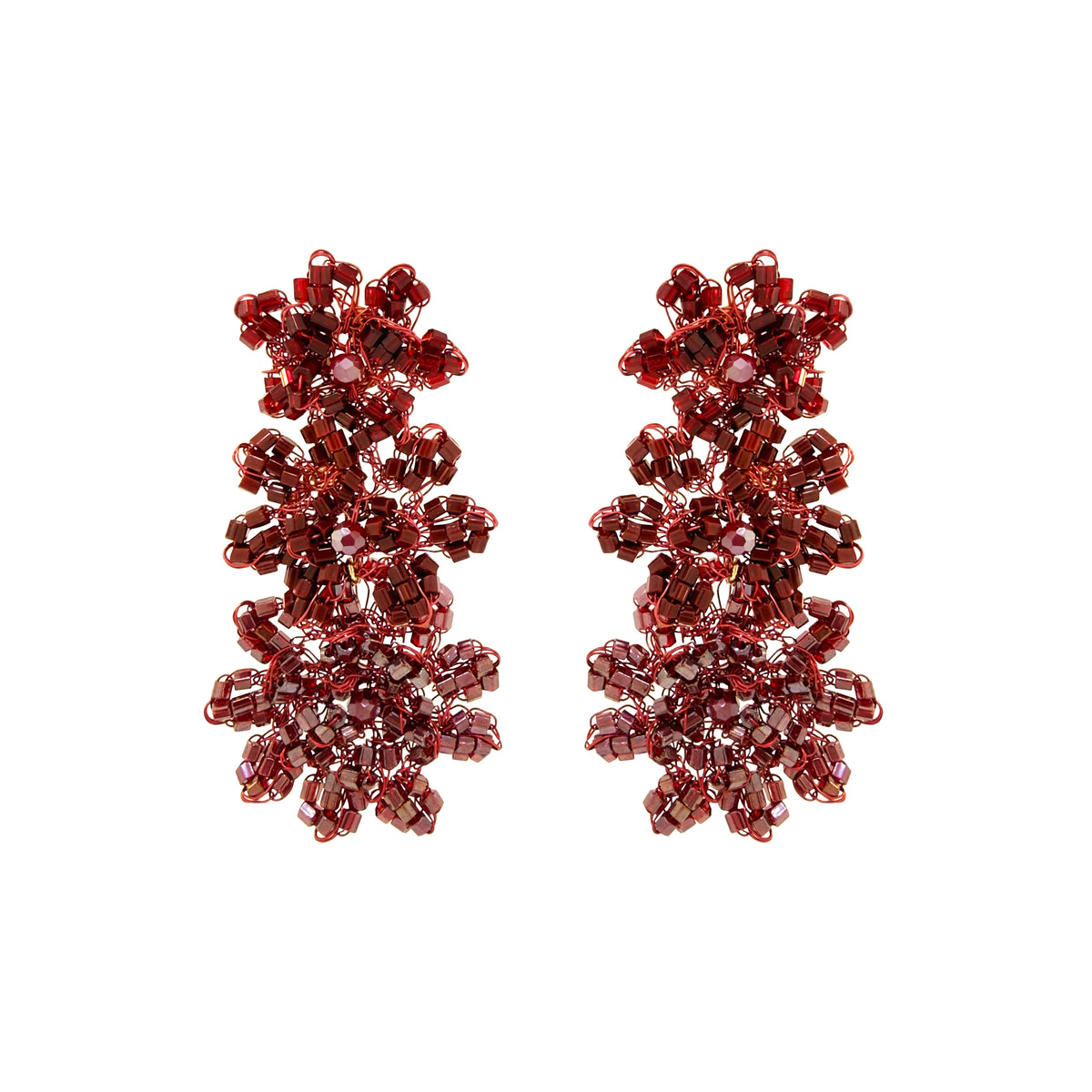 A pair of dangling beaded earrings made of faceted burgundy-red beads arranged in a floral, snowflake-like cluster design, shown on a plain white background. Shop Burgundy Mix Lily Earrings, featuring cascading hand-crocheted flowers with shimmering crystals and beads. Lightweight and handmade in Brazil.
