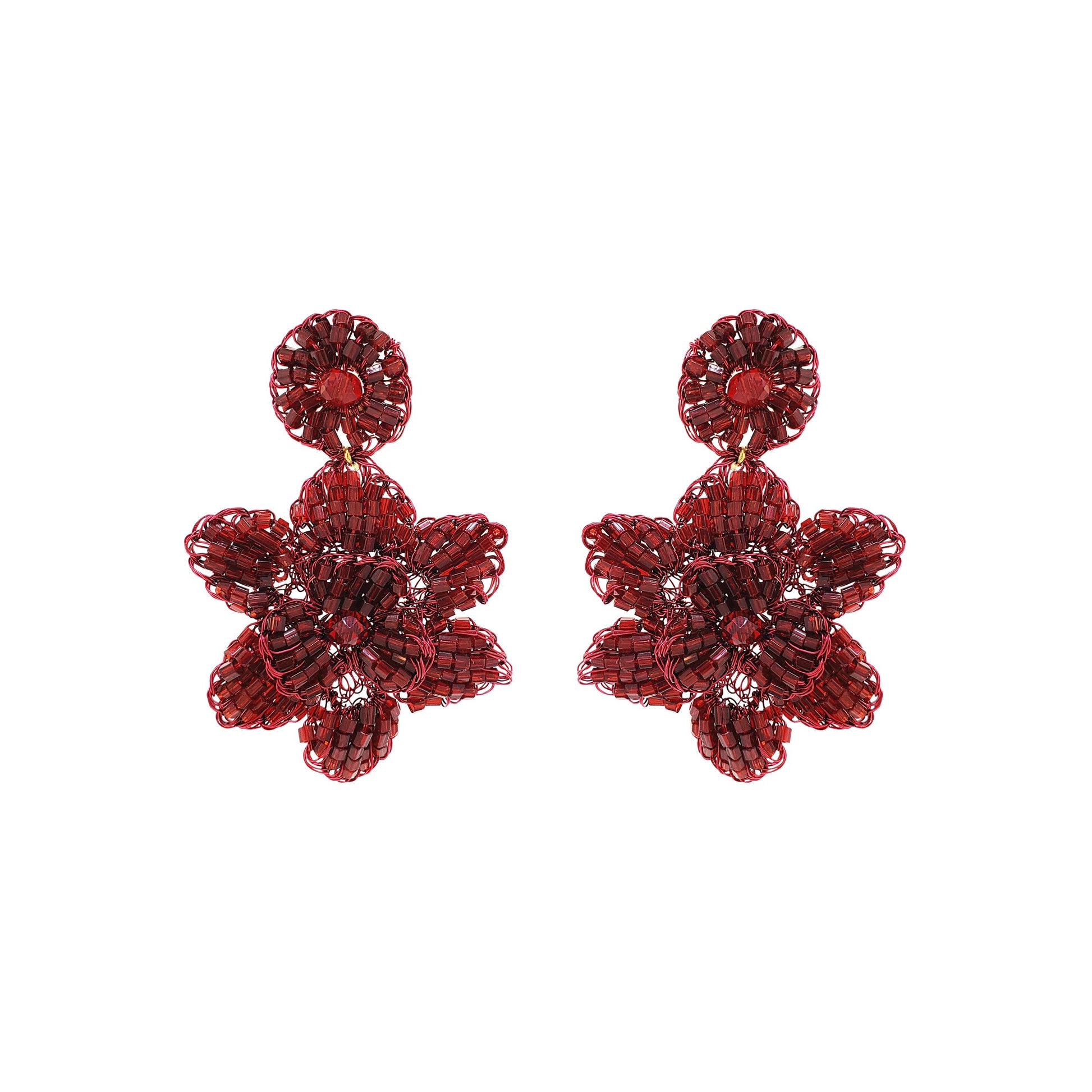 A pair of cherry red, hand-crocheted floral earrings made with enameled copper wire, displayed against a white background. Mini floral hand-crocheted dangle earrings handmade in Brazil with shiny enameled wire and deep cherry red bead accents.
