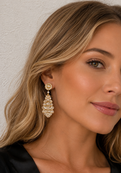 Close-up of a woman wearing a decorative earring against a neutral background
