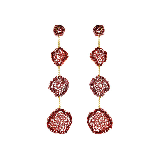 A pair of long drop earrings with three stacked textured circular segments in a deep red hue, separated by small gold chains, on a plain white background.