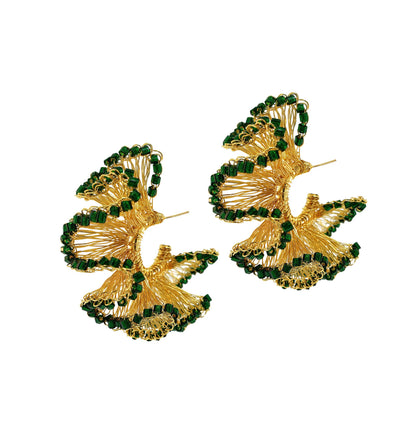 A pair of hand-crocheted hoop earrings with green and gold patterns, made with 18k gold filled wire. Green and Gold Rio Hoop handmade crochet earrings featuring sculptural ruffled 18K gold-filled wire accented with rich dark green crystals.