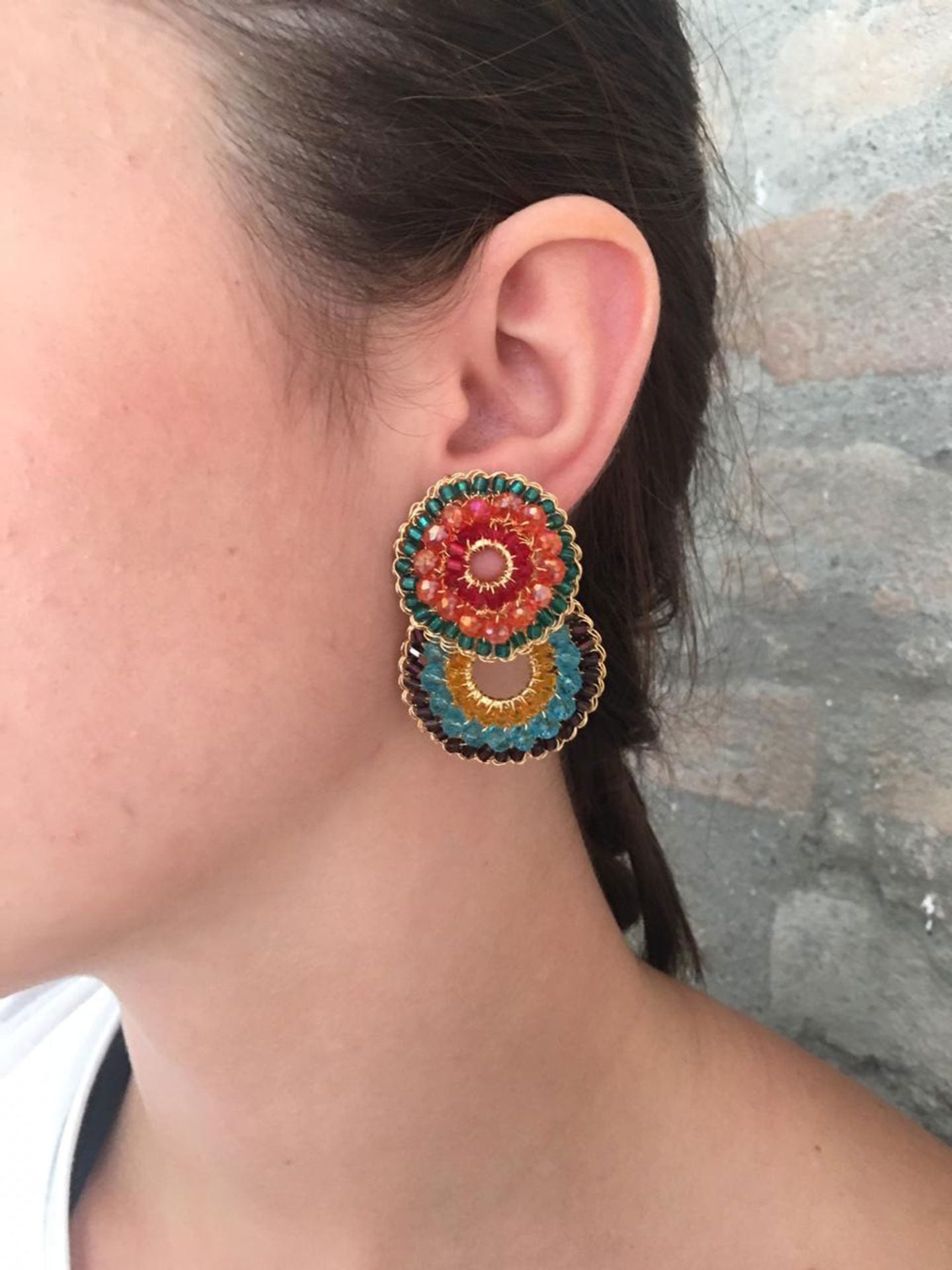 Multicolor hand-crocheted double-circle cascade earrings with gold wire, featuring turquoise, orange, yellow, burgundy, and red crystal beads, handmade in Brazil.