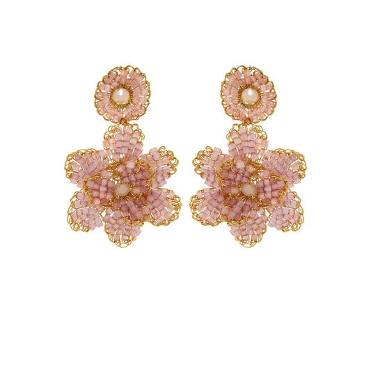 A pair of hand-crocheted earrings with gold and pink detailing, resembling a floral pattern, displayed against a plain background. Floral hand-crocheted dangle earrings handmade in Brazil with 18 karat gold filled wire and delicate mauve bead accents.