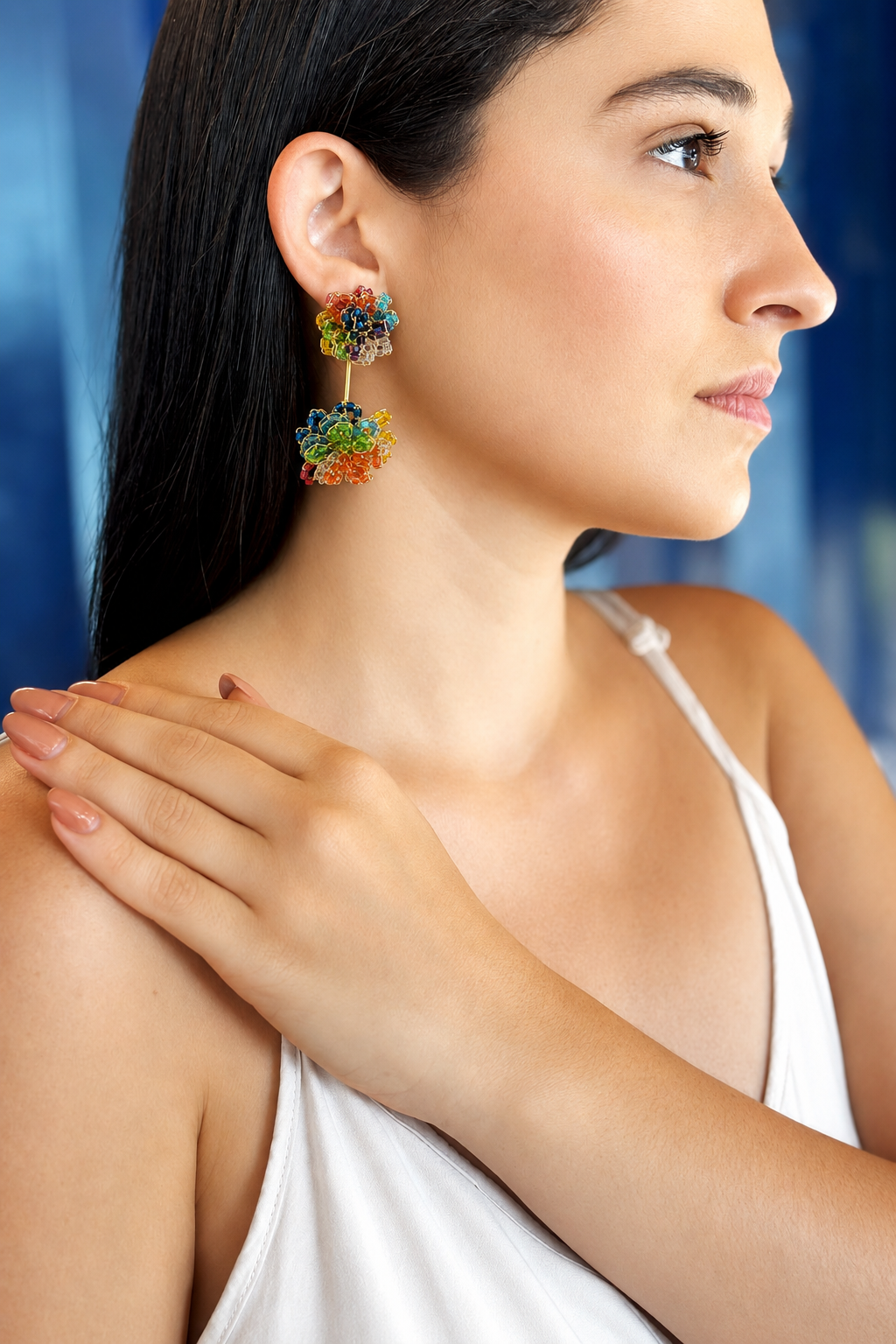 Woman wearing colorful earrings with a blue background