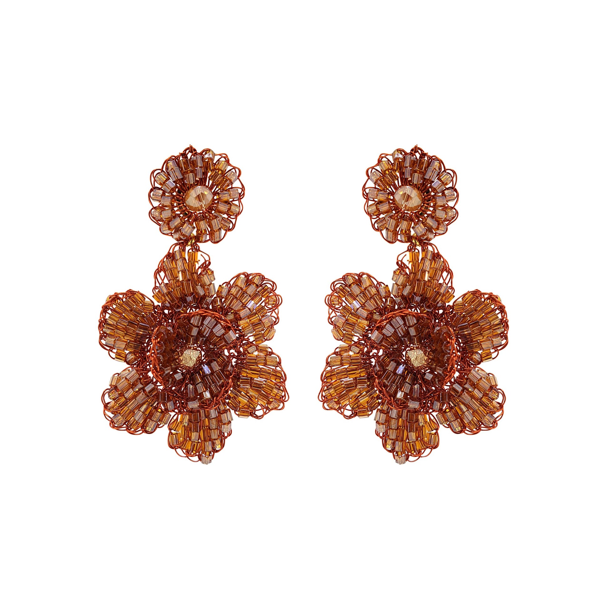 A pair of handmade crochet earrings with a floral pattern in a bronze color. Mini floral hand-crocheted dangle earrings handmade in Brazil with shiny enameled wire and amber-toned bead accents.