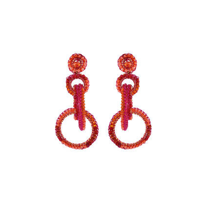 A pair of hand-crocheted hoop earrings with fuchsia and orange enameled wires, adorned with pink crystals. Interlocked link hand-crocheted earrings handmade in Brazil with bright fuchsia and orange tones, sparkling bead accents, and layered circular links.