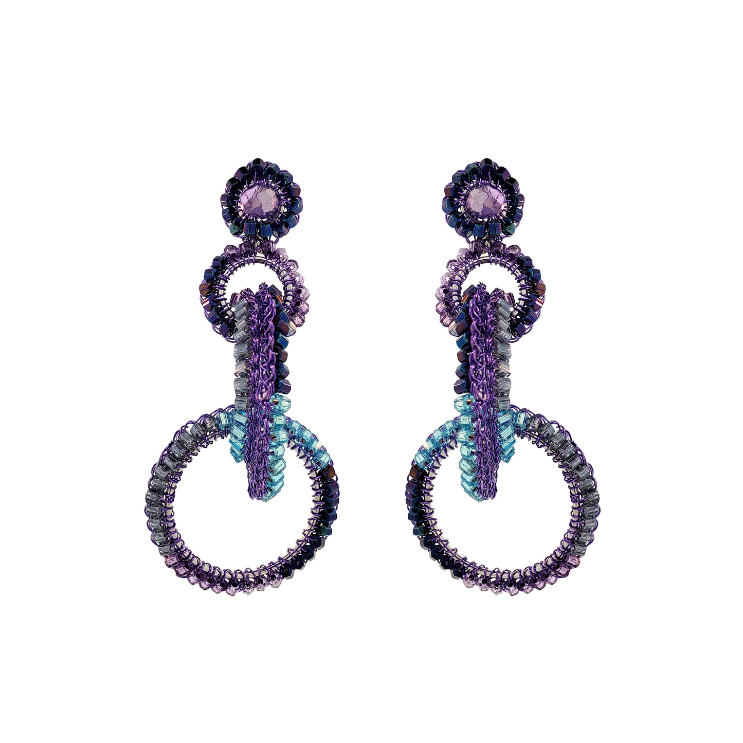 A pair of hand-crocheted earrings with enameled wire and multicolored crystals, displayed against a white background. Interlocked link hand-crocheted earrings handmade in Brazil with rich purple enameled wire, sparkling crystal accents, and teal, lavender, and smoky-toned details.