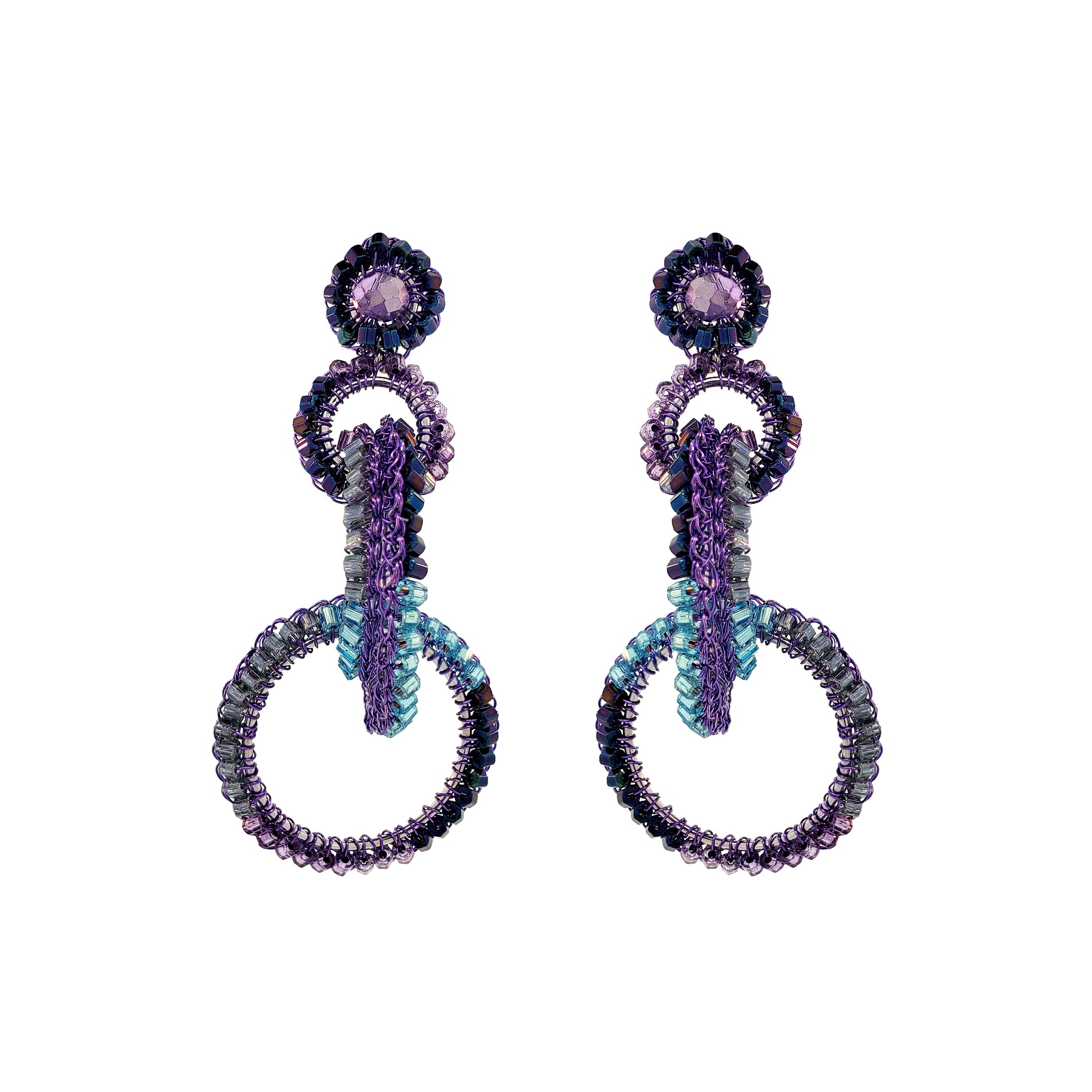A pair of hand-crocheted earrings with enameled wire and multicolored crystals, displayed against a white background. Interlocked link hand-crocheted earrings handmade in Brazil with rich purple enameled wire, sparkling crystal accents, and teal, lavender, and smoky-toned details.