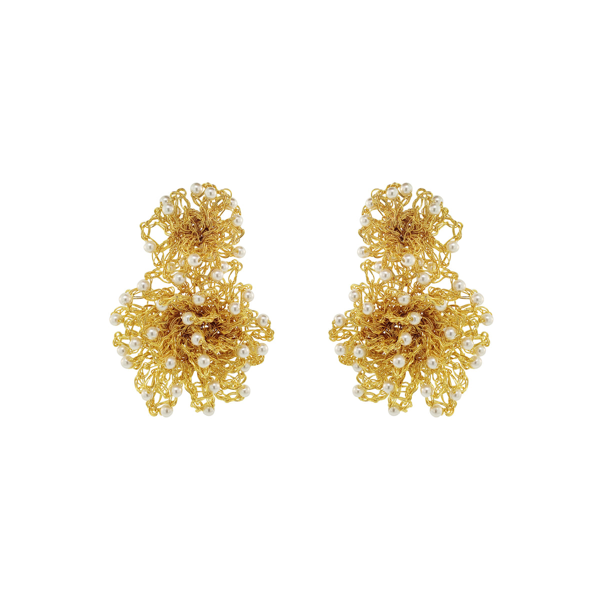 A pair of gold-toned statement earrings with intricate floral wirework and small white pearl accents, displayed on a solid white background. Hand-crocheted gold Double Mandala earrings with dimensional floral details and white pearl-like bead accents, handmade in Brazil.