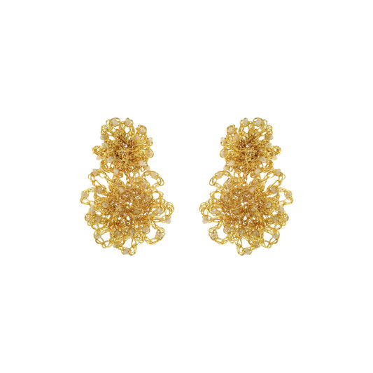 Pair of gold floral earrings on a white background. Hand-crocheted gold Double Mandala earrings with dimensional floral details and white pearl-like bead accents, handmade in Brazil.