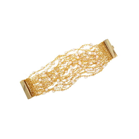 A hand-crocheted gold-colored cuff bracelet with a shiny metallic finish and a magnetic clasp. Hand-crocheted gold cuff bracelet handmade in Brazil with 18 karat gold filled wire, delicate pearl accents, and magnetic clasp.