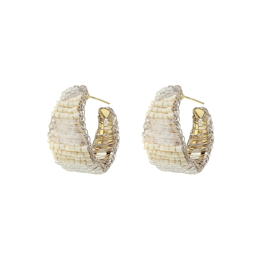 Pair of gold and white hoop earrings on a white background. Vibrant handmade crochet hoop earrings with enameled wire and crystals, handcrafted in Brazil by skilled artisans.