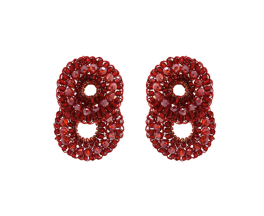 Pair of red beaded earrings shaped like the number 8 on a white background. Red hand-crocheted double-circle cascade earrings with sparkling crystals and glass beads, handmade in Brazil with enameled copper wire.