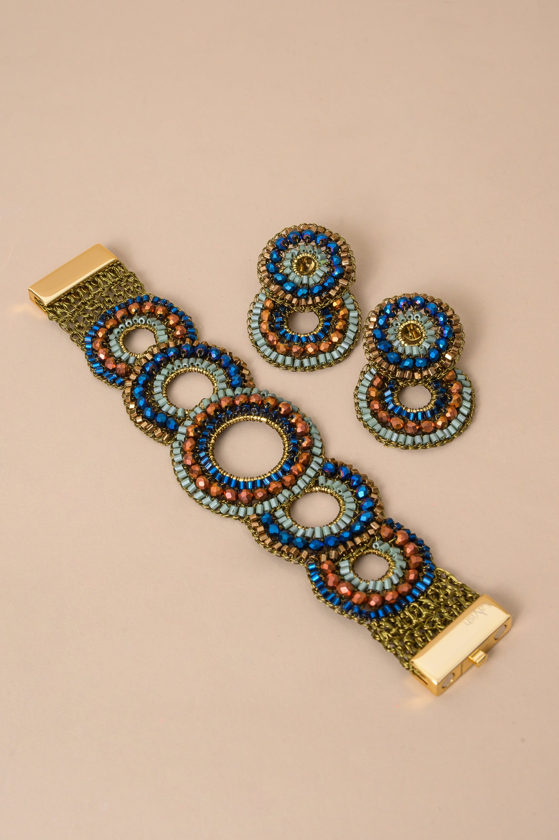 Riviera Mix Gush handmade crochet bracelet featuring layered circles with blue, sage green and bronze crystals, gold-filled wire and magnetic clasp.