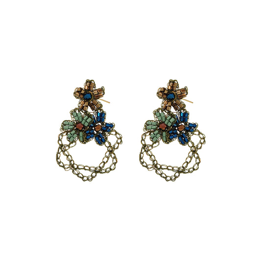 A pair of ornate dangling earrings with antique gold-tone chains and floral clusters of blue, green, and brown rhinestones, shown on a plain white background.  Shop Riviera Mix Aster Trio Earrings, handcrafted in Brazil with floral crochet details, crystals, beads and 18K gold-filled and enameled wire.