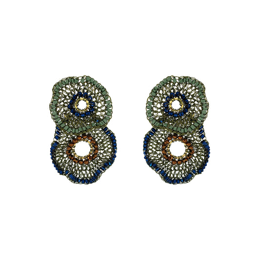 A pair of large, circular beaded earrings with a layered design. The earrings feature textured green, deep blue, and brown beaded rings with openwork centers, set against a plain white background. Shop Riviera Mix Crista Duo Earrings, handcrafted in Brazil with 18K gold filled and enameled wire. Lightweight statement earrings with colorful bead accents.