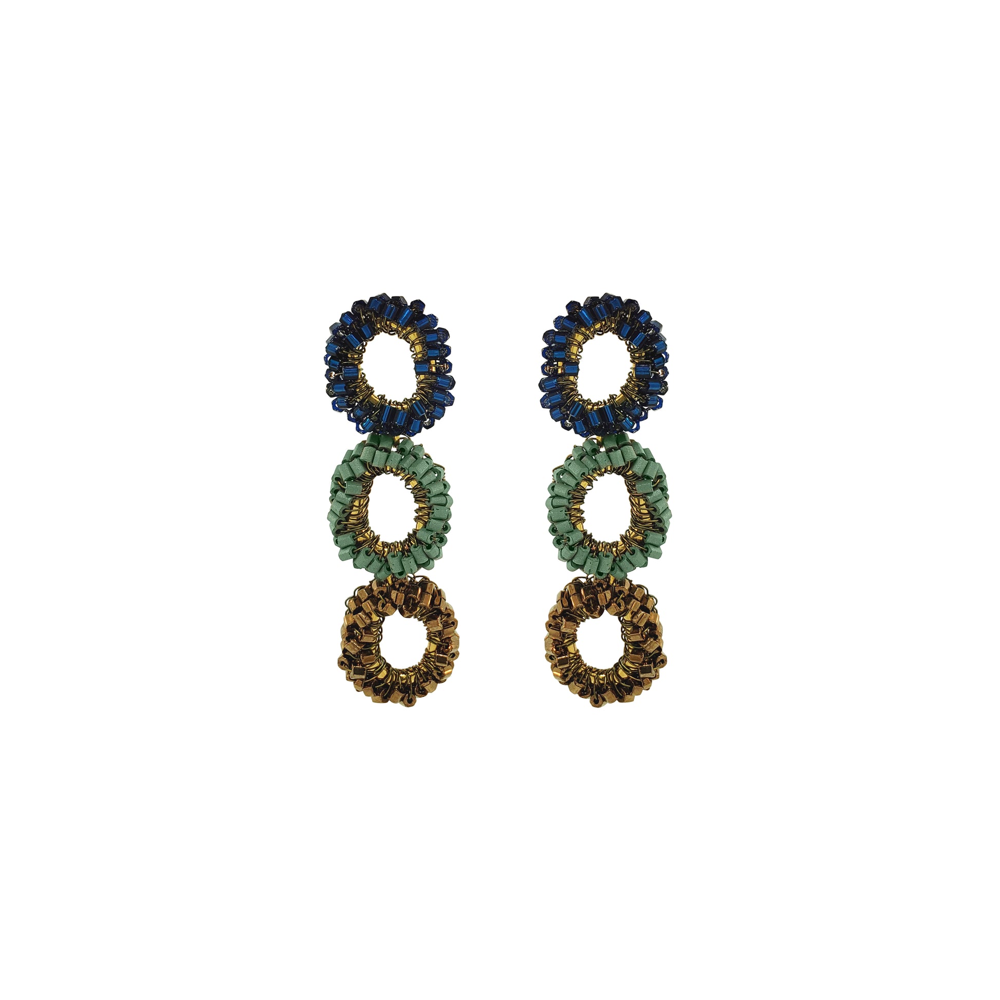 A pair of beaded drop earrings with three stacked circular rings in navy blue, sage green, and gold-tone metal on a plain white background. Shop Riviera Mix Halo Earrings, handcrafted in Brazil with 18K gold filled wire and shimmering crystals. Lightweight, colorful statement earrings.