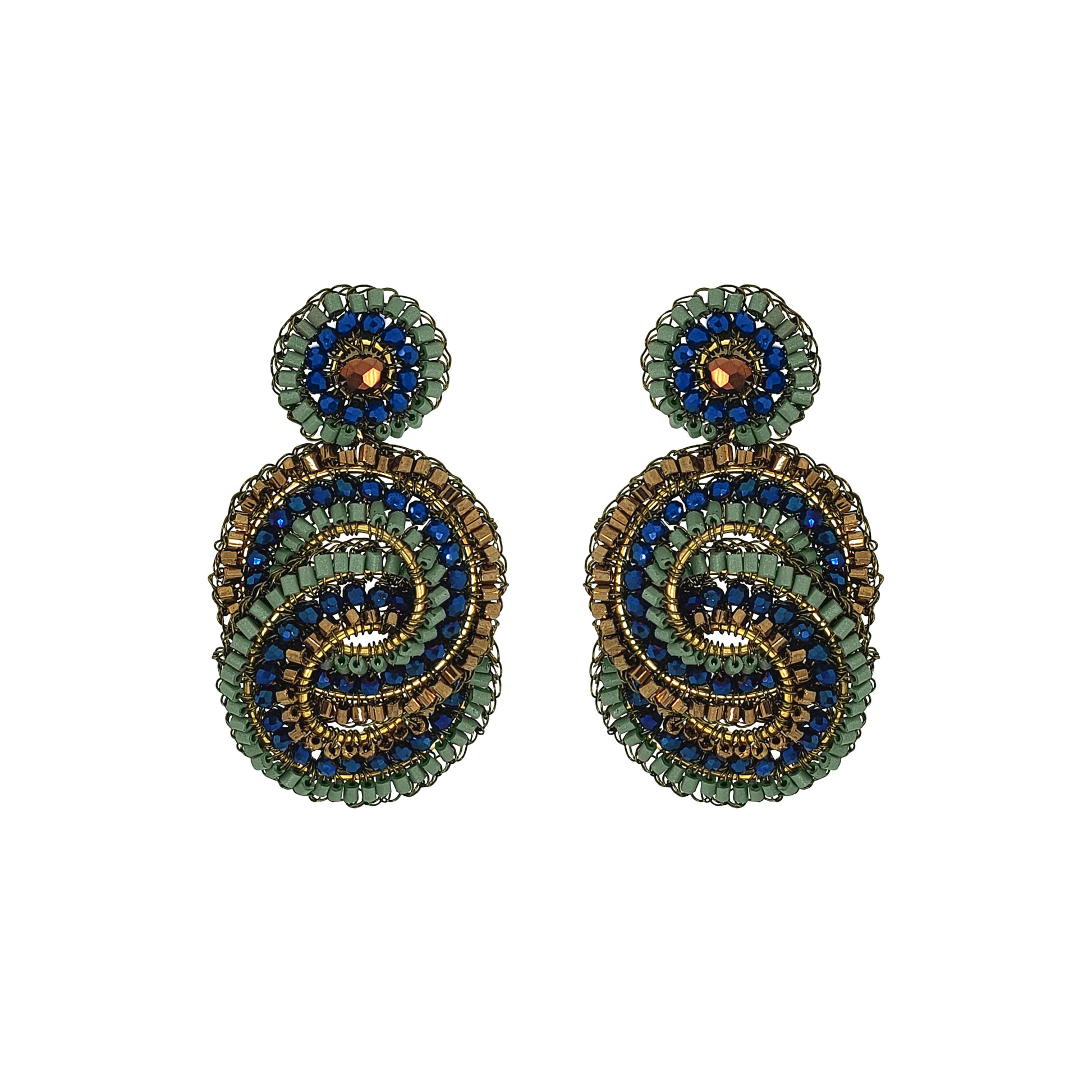 A pair of handmade beaded drop earrings featuring a spiral design in green, blue, and gold, with a small round green and blue top piece on each earring, set against a plain white background. Shop Riviera Mix Loki Earrings, handcrafted in Brazil with 18K gold filled and enameled wire, colorful crystals and intricate crochet detailing.
