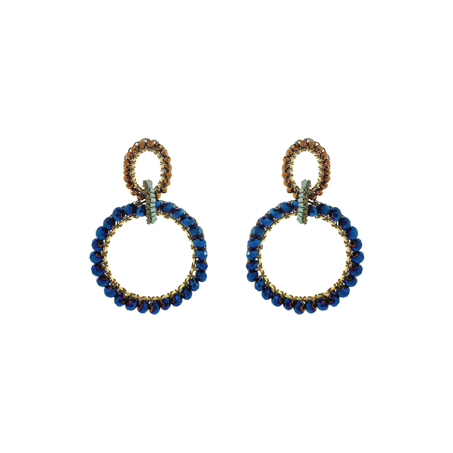 A pair of statement drop earrings featuring large open circular hoops set with deep blue faceted beads and accented with gold-toned metal and small green crystals, shown on a plain white background. Shop Riviera Mix Lola Maxi Earrings, handcrafted in Brazil with 18K gold-filled wire and sparkling blue and bronze crystals in a bold double-hoop design.