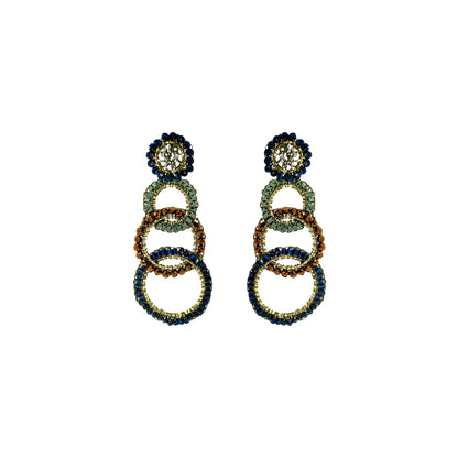 A pair of statement drop earrings featuring stacked interlocking rings in navy blue, emerald green, and gold, with a floral stud top, shown on a plain white background. Shop Riviera Mix Olympia Earrings, handcrafted in Brazil with 18K gold filled wire and colorful crystal-accented links. Lightweight, bold and unique.