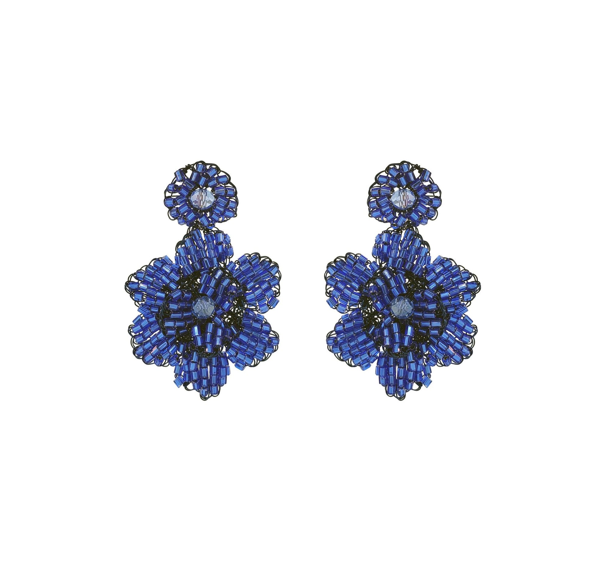 A pair of hand-crocheted floral earrings in blue, made from enameled wire, with hypoallergenic properties. Mini floral hand-crocheted earrings handmade in Brazil with enameled wire, lightweight artisan design, and delicate floral texture.