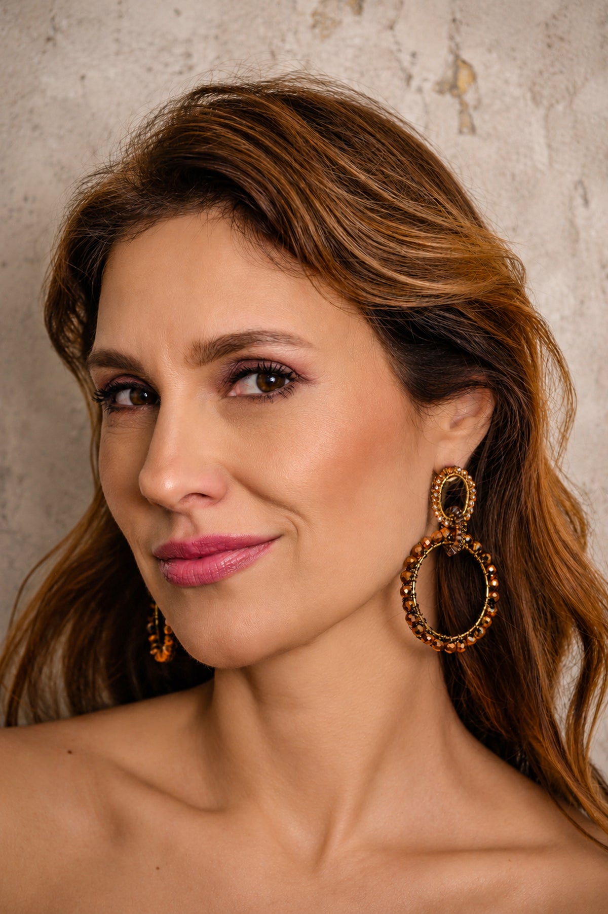 Woman wearing large hoop earrings against a neutral background. double circle earrings, statement earrings, gold circle earrings, crystal earrings, hand crocheted earrings, Brazilian jewelry, handmade earrings, lightweight statement earrings, hypoallergenic earrings, artisan jewelry