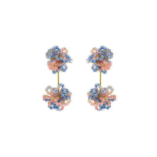 Pair of floral earrings with pink and blue stones on a white background. Drizzle hand-crocheted dangle earrings made with 18 karat gold filled wire, handcrafted in Brazil with hypoallergenic and nickel-free materials.