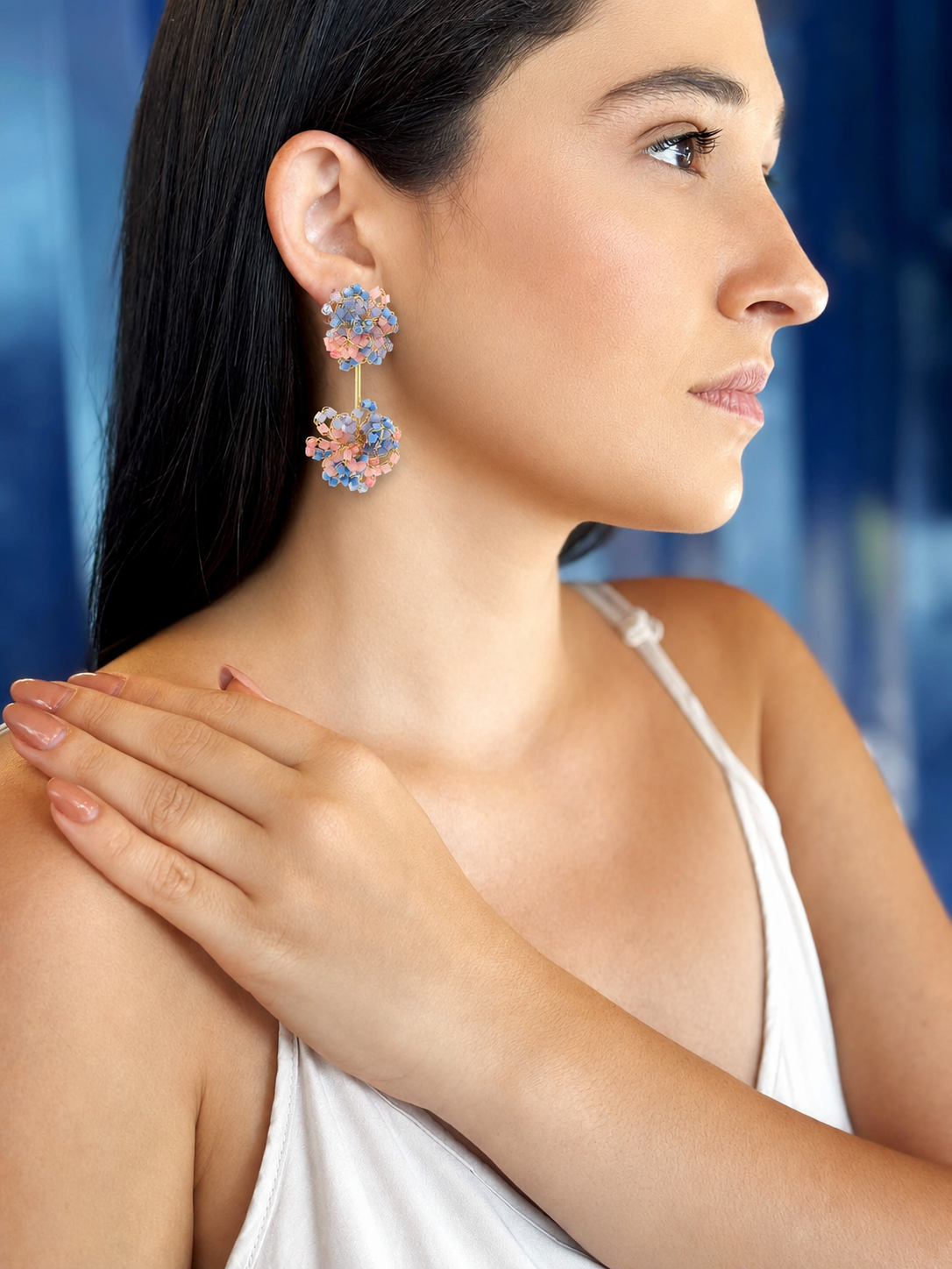 Woman wearing a floral earring with a blue gradient background