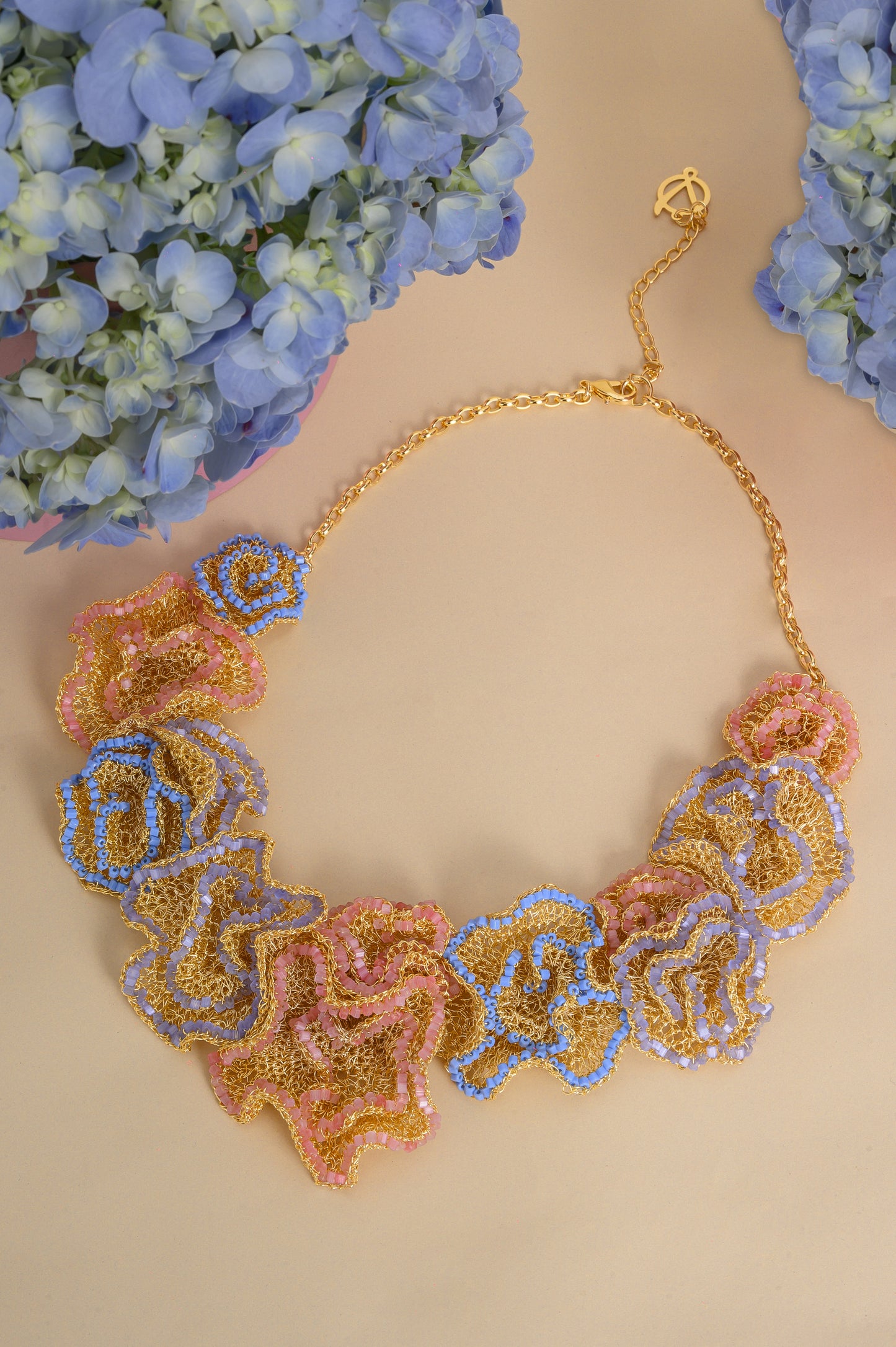 Decorative necklace with floral patterns on a beige background with blue flowers.