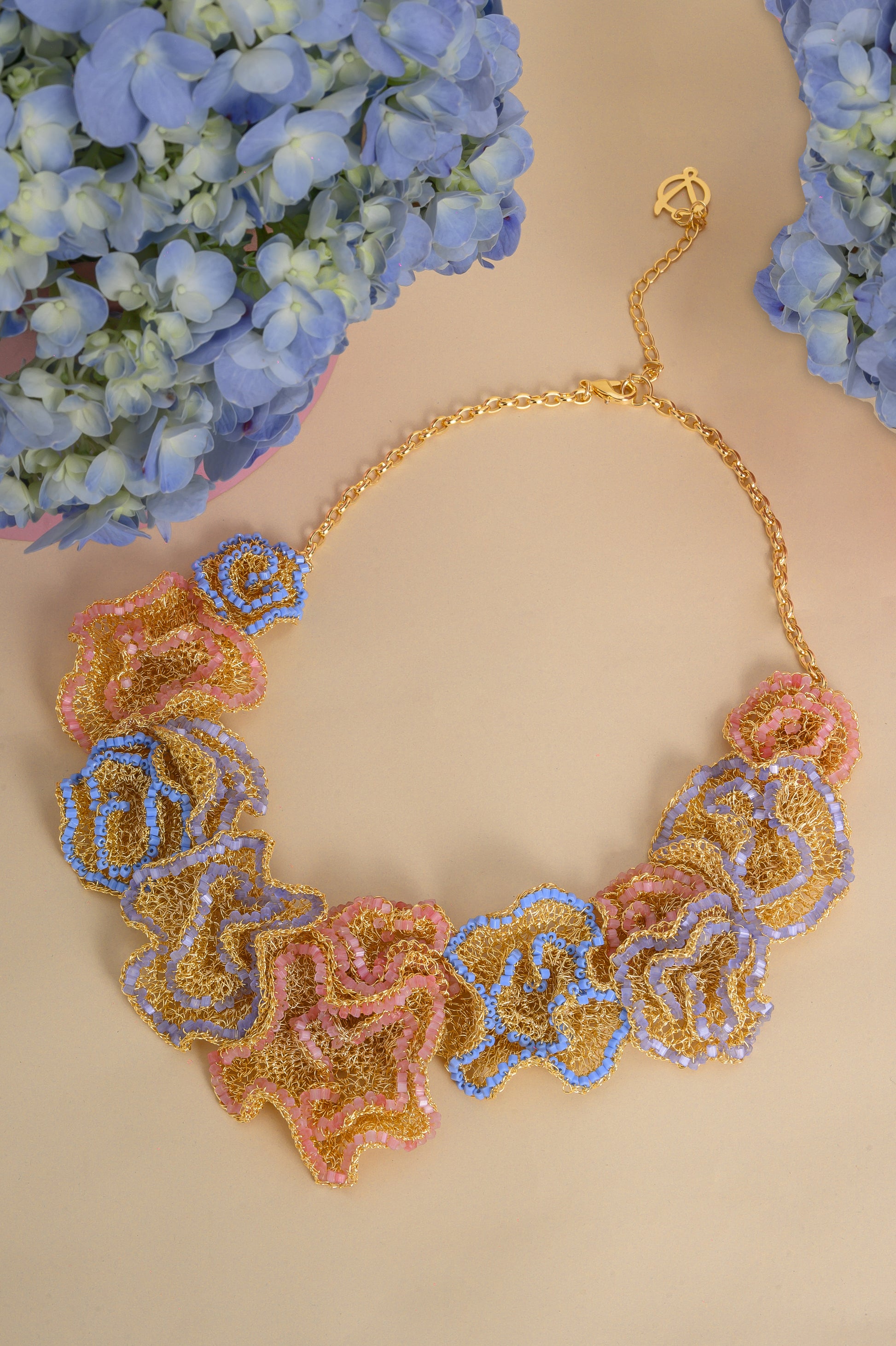 Decorative necklace with floral patterns on a beige background with blue flowers.
