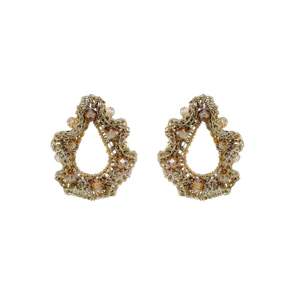 A pair of gold-toned teardrop-shaped earrings with intricate beadwork, sequins, and clear rhinestone accents, displayed on a solid white background. Nalu Teardrop hand-crocheted gold earrings with sculptural ruffled wirework and champagne crystal accents, handmade in Brazil.