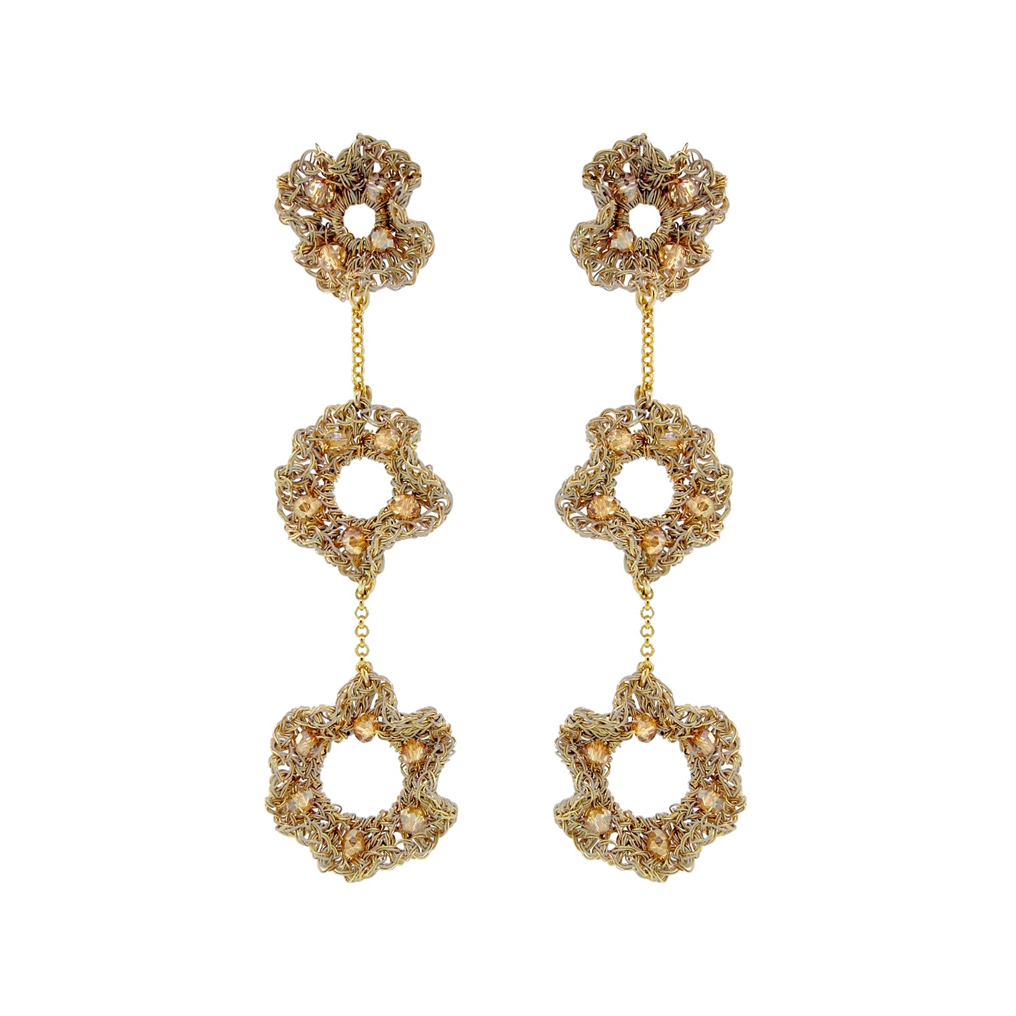 A pair of gold-tone dangle earrings with three stacked flower-shaped links, each adorned with clear rhinestones and accented with small gold beads, set against a plain white background. Hand-crocheted gold ruffled cascade earrings with three floral drops and champagne crystal accents, handmade in Brazil.