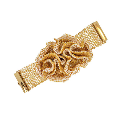 A gold-colored wide crochet bracelet with a floral pattern, adorned with white and clear crystals, secured with a magnetic clasp. Hand-crocheted abstract floral statement cuff in 18K gold-filled wire with white and clear crystal accents, handmade in Brazil.