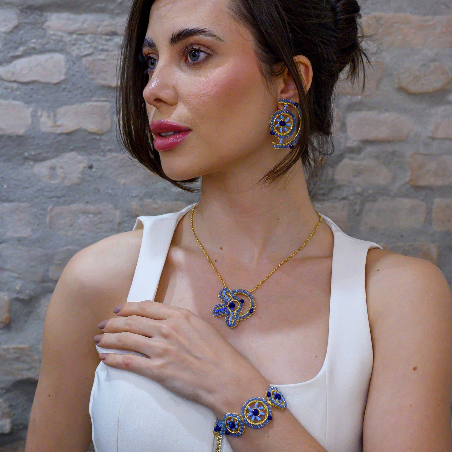 Woman wearing jewelry against a stone wall background